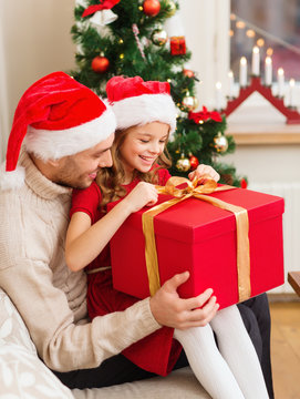 smiling father and daughter opening gift box