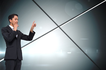 Composite image of thoughtful asian businessman pointing