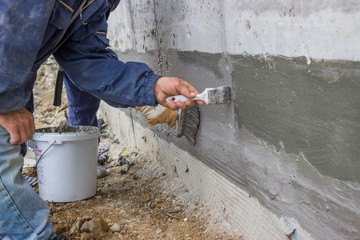 Construction workers with brush applied hydro insulation 2