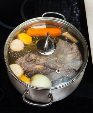 boiling of beef broth with seasoning vegetables