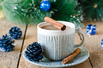 A cup of coffee on a wooden table with Christmas decorations