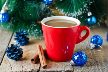 A cup of coffee on a wooden table with Christmas decorations