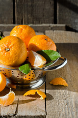 Tangerines in a bowl on a wooden table