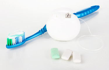 Toothbrush, chewing gum and dental floss isolated on white