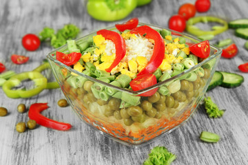 Tasty salad with fresh vegetables on wooden table
