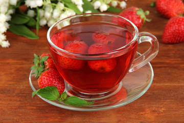 Delicious strawberry tea on table close-up
