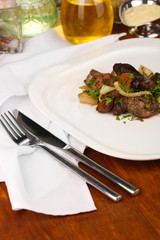 Fried chicken livers on plate on wooden table close-up