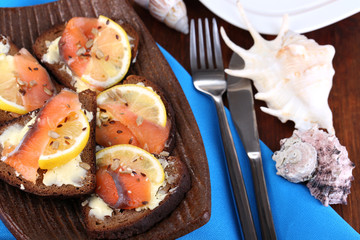 Salmon sandwiches on plate  on wooden table close-up