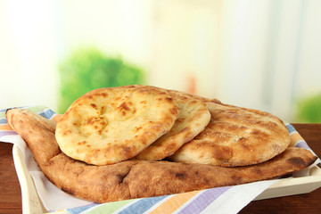Pita breads on tray on table on bright background