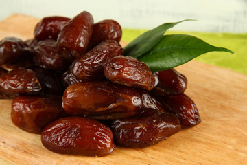 Dried dates on wooden stand on table on wooden background