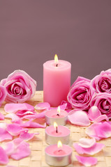 Fototapeta na wymiar Spa Candles and rose with petals on mat