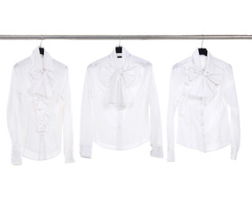 Three white female clothing on hanger in a row