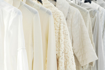 Stylish white jacket on hangers at the show