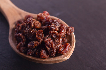 raw raisin on wooden spoon as baking ingredient