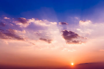 Sunset with sun, clouds and light rays.