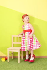 The girl in a bright dress and red shoes large size