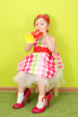 Funny girl in a bright dress and large shoes