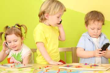 Fototapeta premium Three children with the phones in hand