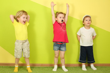 Two boys and a girl standing at the bright green wall