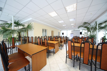 Interior of conference hall with row of chairs and tables
