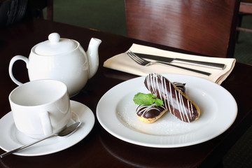 Eclairs with cream in chocolate coating on a plate