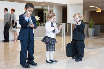 Fototapeta premium Children with communication devices in business clothing