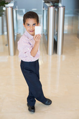 boy in shirt with card in his hand near entrance
