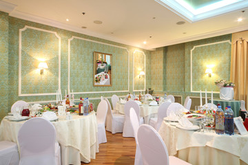 hall with tables in restaurant decorated for wedding