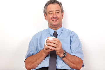 Man with cup sitting on the floor