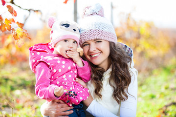Obraz premium Young mother and her cute girl have fun in autumn vineyard