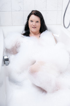 Young woman has fun in the bathtub