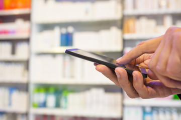 Man using a mobile phone in Pharmacy