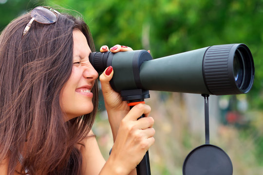 Positive girl who is watching in spotting scope.