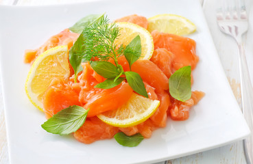fresh salmon with lemon on the white plate