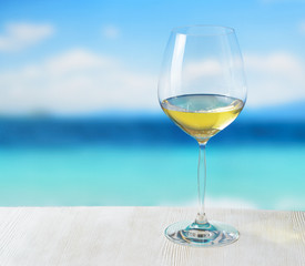 Obraz premium Glass of wine on beach background