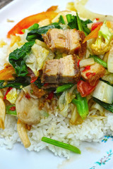 Crispy roasted  pork stir fry with vegetables and rice.