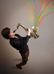 Attractive musician playing on saxophone while colorful abstract