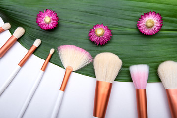 Makeup Brushes on green leaf with small flowers