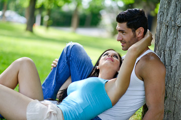 Fototapeta premium Happy smiling couple laying on green grass
