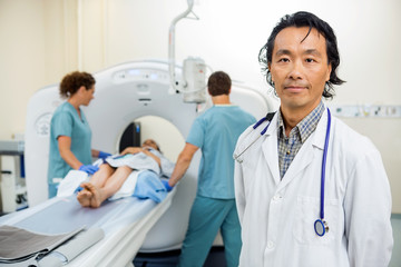 Radiologist With Nurses Preparing Patient For CT Scan Test