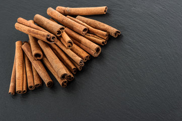cinnamon sticks on black stone plate background