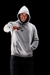 Young man with hood over his head with a gun symbolizing crime