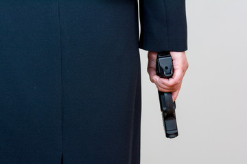 Woman holding hand gun on white background