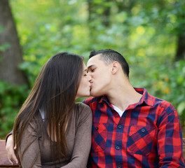 Fototapeta premium Couple kissing at the bench in park