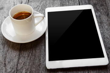 digital white tablet and coffee cup on wooden table