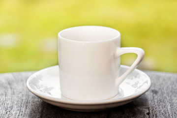 White cup of coffee on table with landscape background