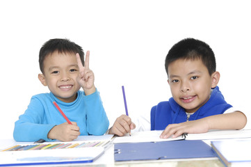 Brother School boy sitting and writing in notebook