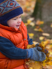Boy carrying fall leaves