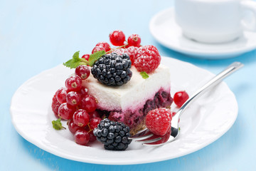 dessert - a piece of cake with fresh berries on blue background
