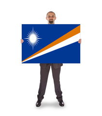 Smiling businessman holding a big card or flag